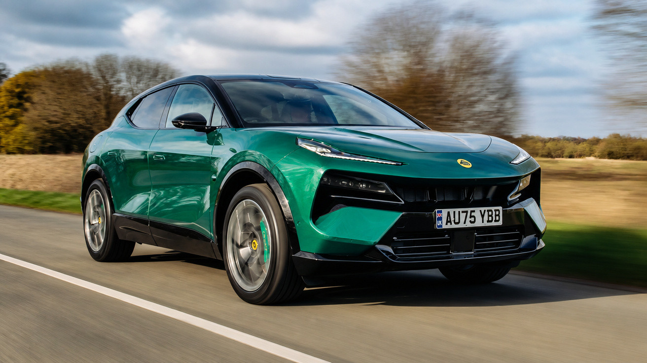 Carro esportivo SUV verde em movimento numa estrada com campo e árvores ao fundo.