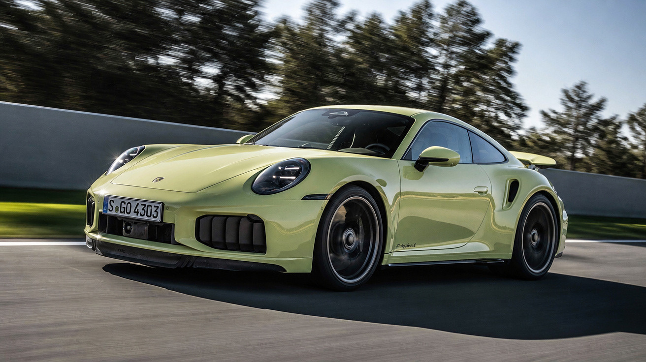 Carro esportivo Porsche 911 Turbo S verde em movimento numa pista com árvores ao fundo.