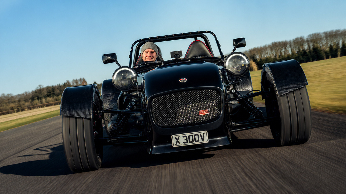 Carro esportivo preto clássico em pista com motorista sorridente usando gorro cinza.