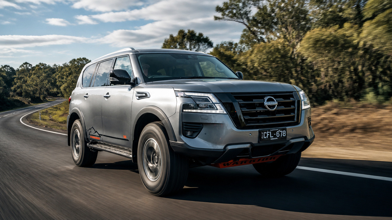 SUV Nissan Pathfinder prata em estrada asfaltada cercada por árvores ao entardecer.